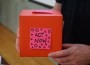 red donation box with a pick sticky note that says act now